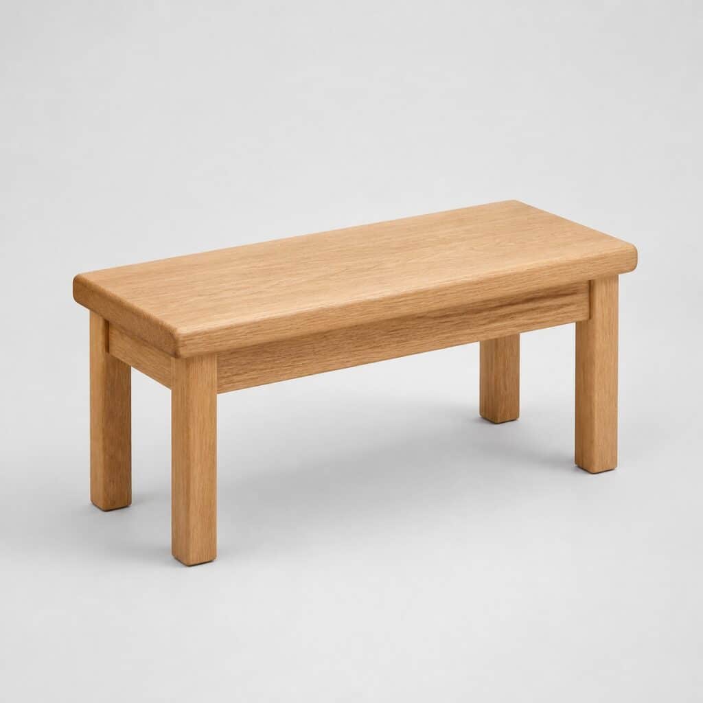 Petit banc en bois clair sans dossier, vue de trois quarts sur fond neutre
